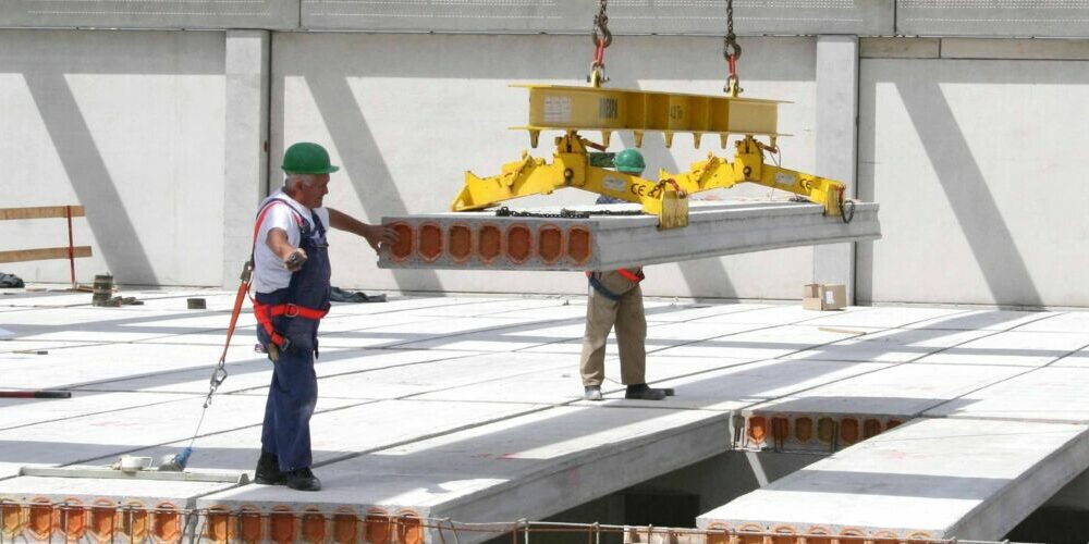 Montage der BRESPA Decke auf der Baustelle mit zwei Bauarbeitern, die diese platzieren.